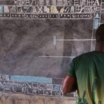 Учител преподава компютърни технологии с дъска и тебешир