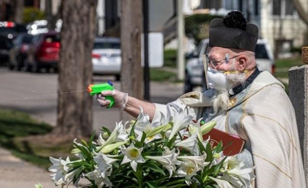 Свещеник който използва воден пистолет за да пръска богомолците със